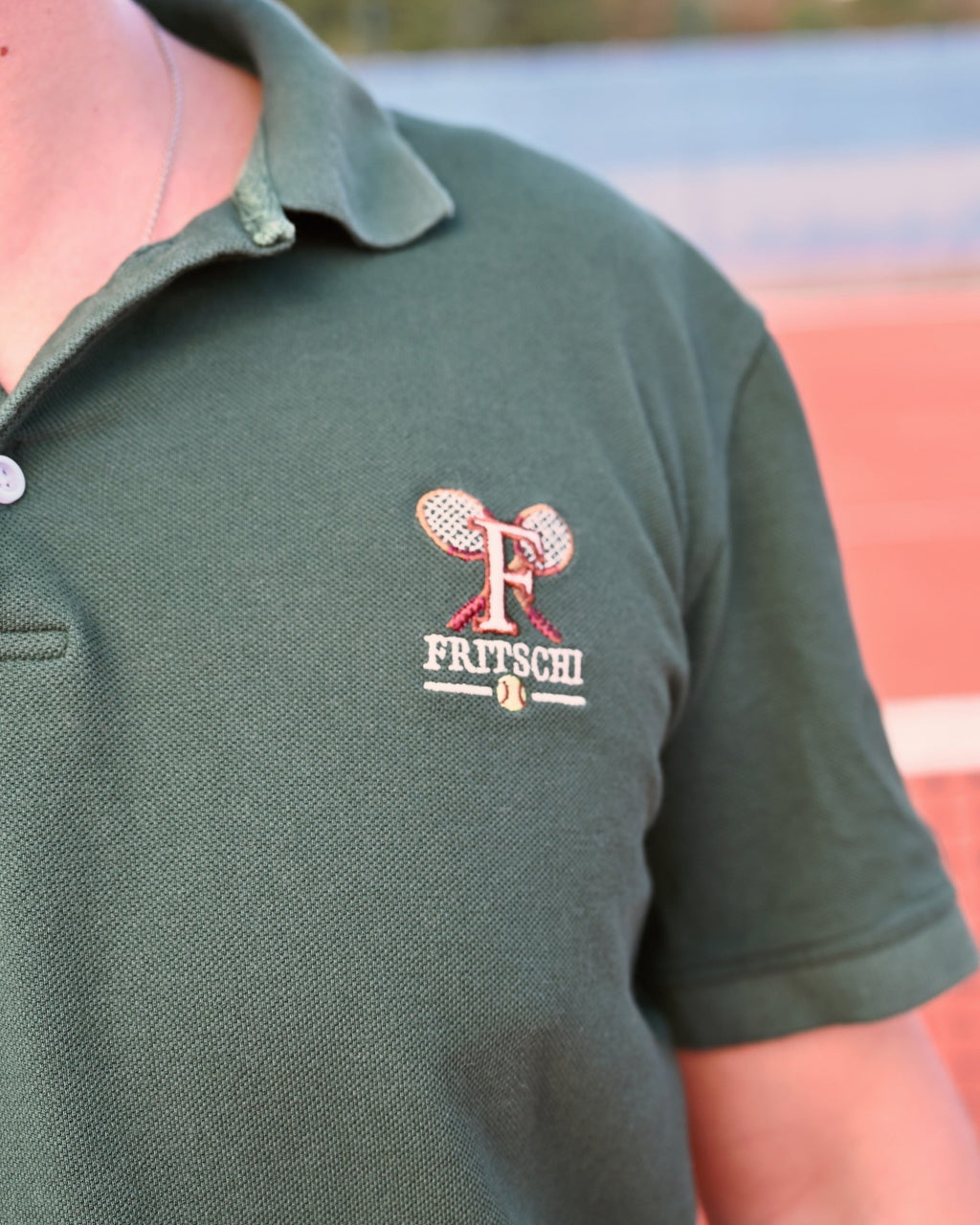 The crossed-racquet Fritschi crest embroidered on the chest